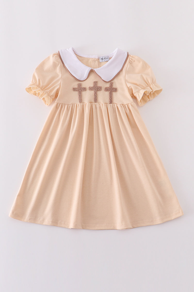 Cream dress with delicate cross french knot pattern, perfect for special occasions.