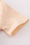 Cream top with delicate cross-stitch knots, perfect for everyday play.