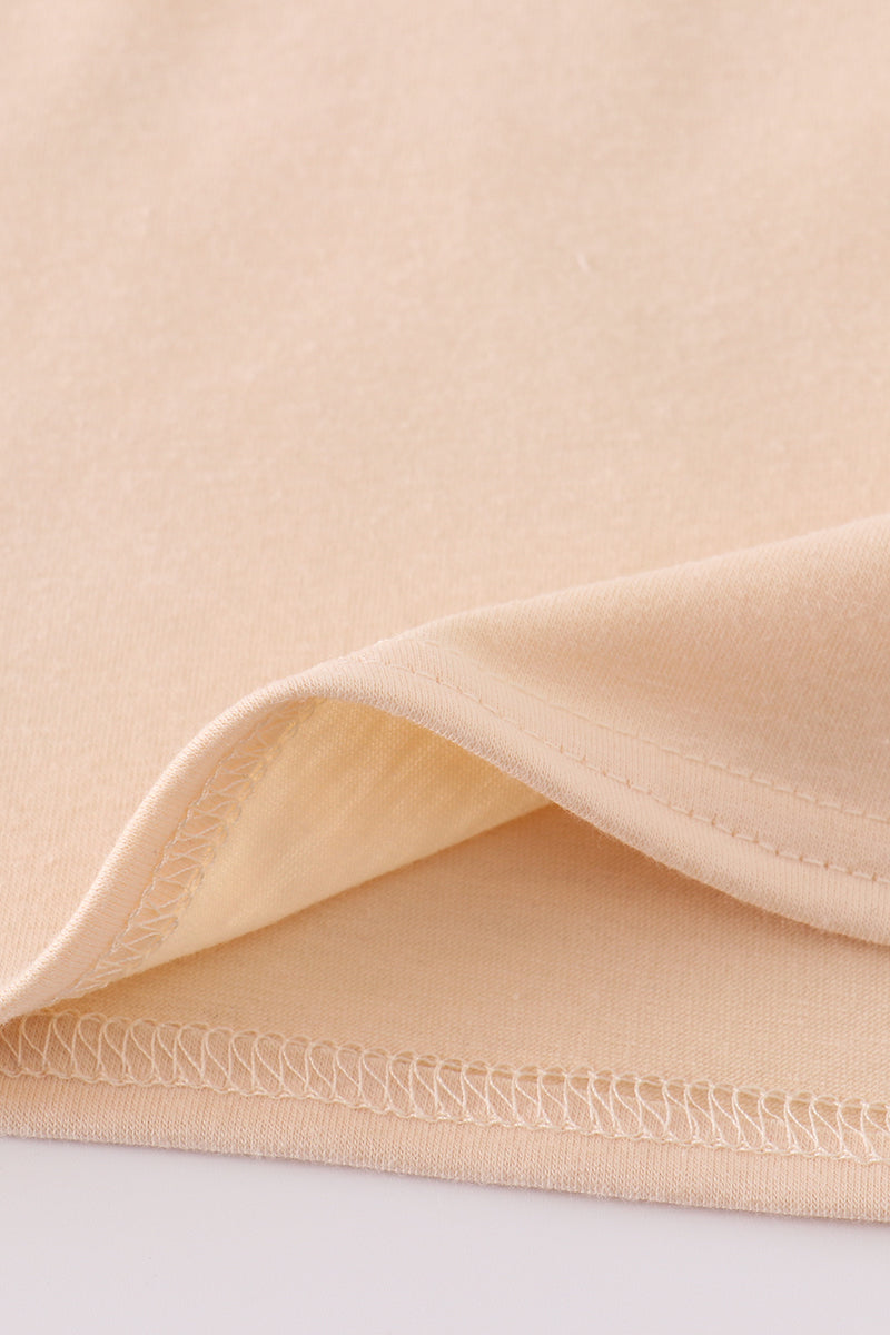 Cream top with delicate cross-stitch knots, perfect for everyday play.