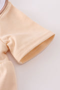 Cream bubble romper with delicate cross French knot embroidery, perfect for special occasions.