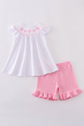 A sweet pink smocked set with delicate cross embroidery, perfect for playdates.
