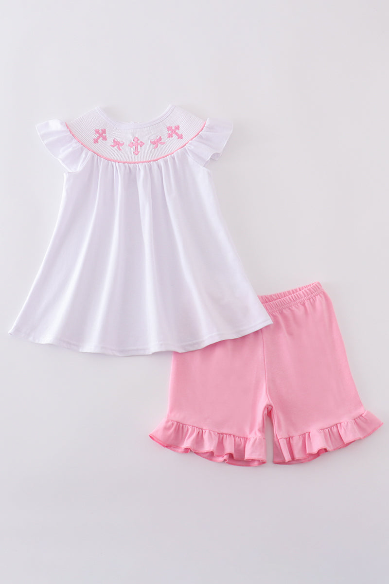 A sweet pink smocked set with delicate cross embroidery, perfect for playdates.