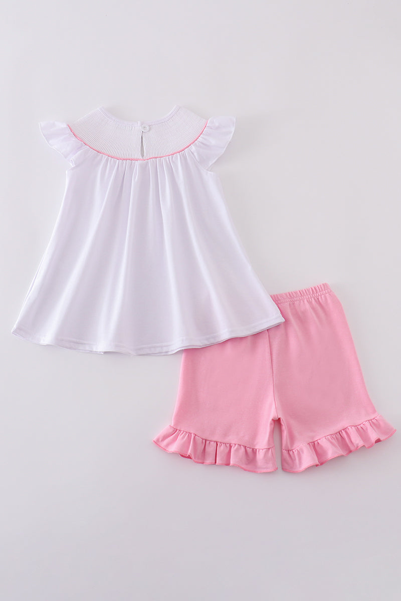 A sweet pink smocked set with delicate cross embroidery, perfect for playdates.