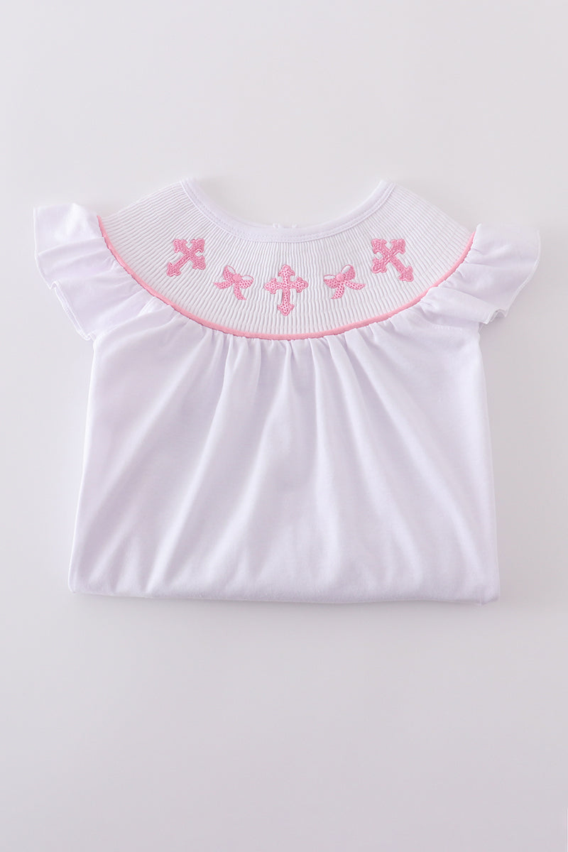 A charming pink dress with cross embroidery and smocked detailing, perfect for playdates.