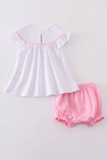 Pink smocked bloomer set with cross embroidery, perfect for special occasions.