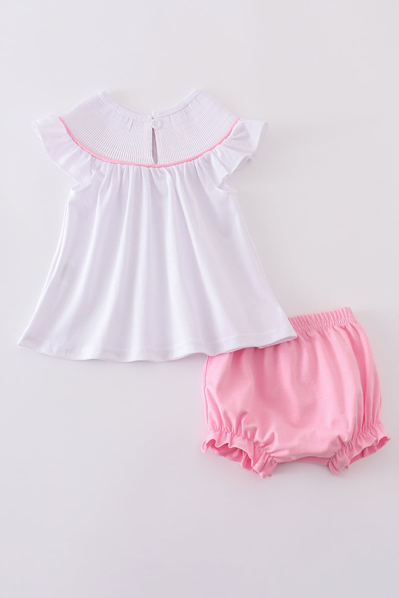 Pink smocked bloomer set with cross embroidery, perfect for special occasions.