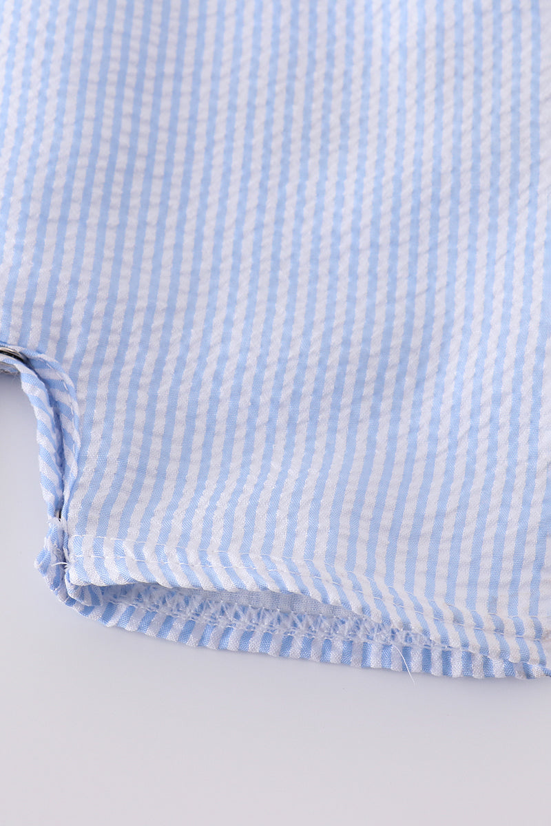 A charming blue smocked set with delicate cross embroidery, perfect for special occasions.