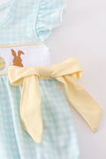 A blue smocked bubble with adorable bunny embroidery, perfect for spring outings.