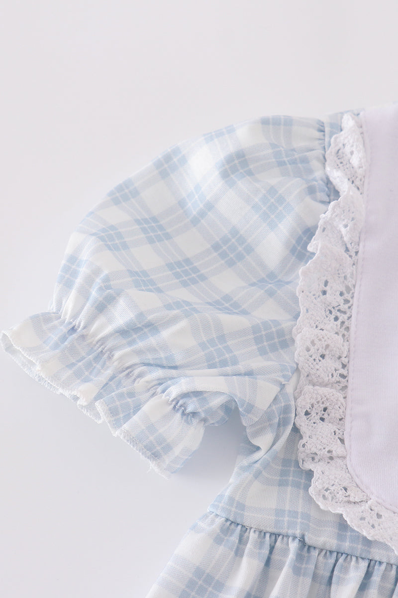 A charming blue plaid dress with "He is Risen" embroidery, perfect for Easter.