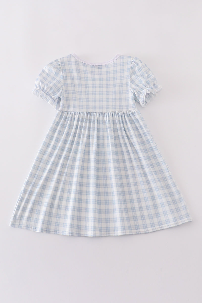 A charming blue plaid dress with "He is Risen" embroidery, perfect for Easter.