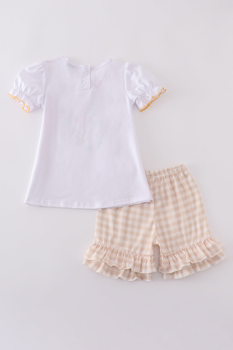 Girls' Easter outfit with pastel cross embroidery and ruffled sleeves.
