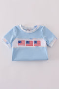 A charming blue bubble romper with delicate flag embroidery, perfect for summer fun.