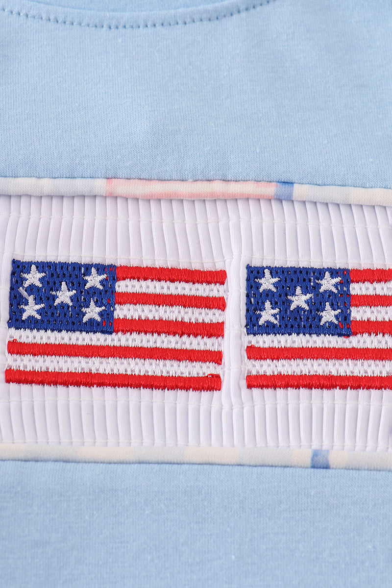 A charming blue bubble romper with delicate flag embroidery, perfect for summer fun.