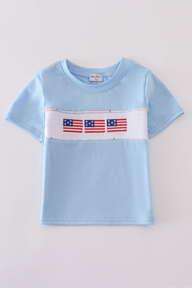 Blue flag embroidery top for kids, featuring playful flag patterns on soft fabric.