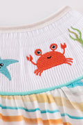 Colorful smocked bubble with rainbow stripes and marine creature embroidery.