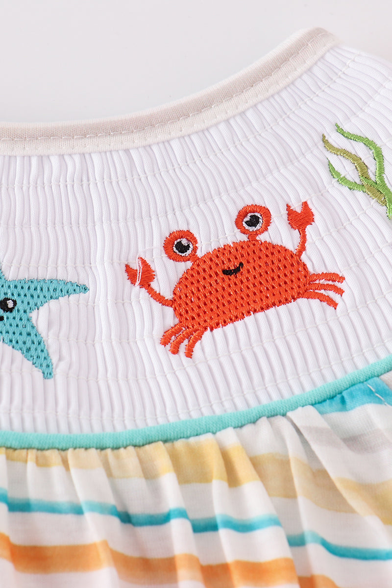 Colorful smocked bubble with rainbow stripes and marine creature embroidery.