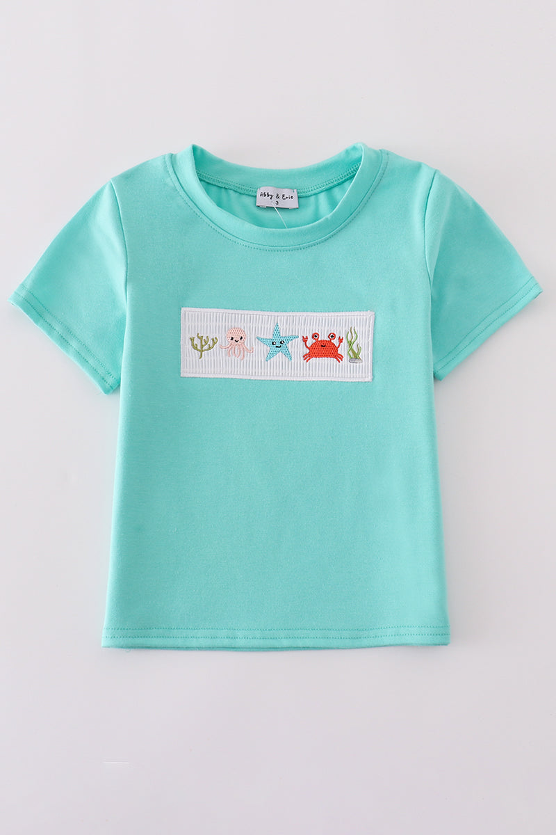 Children's blue smocked top with cute marine creature embroidery.