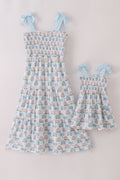 Matching blue hydrangea bow smocked dresses with delicate floral pattern for mom and child.