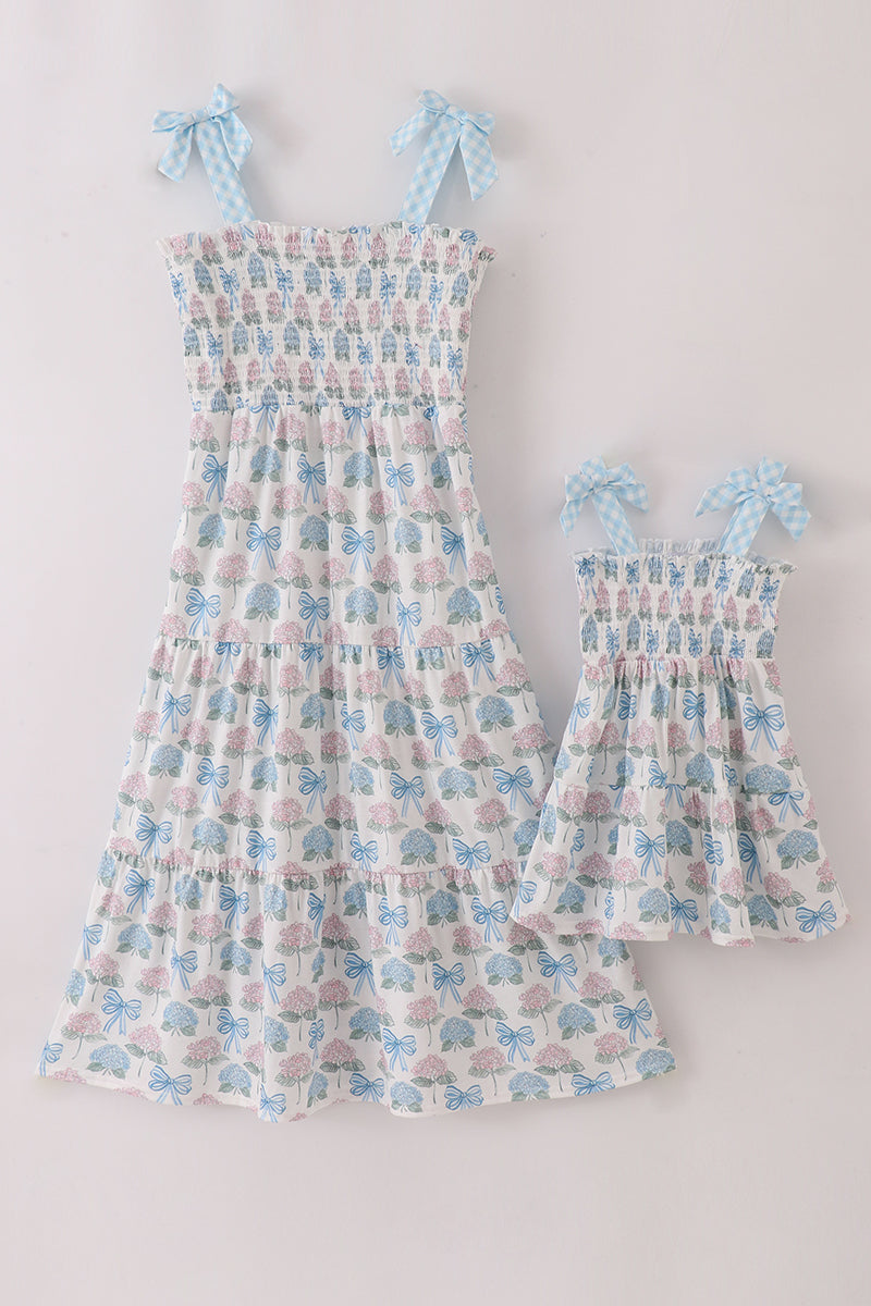 Matching blue hydrangea bow smocked dresses with delicate floral pattern for mom and child.