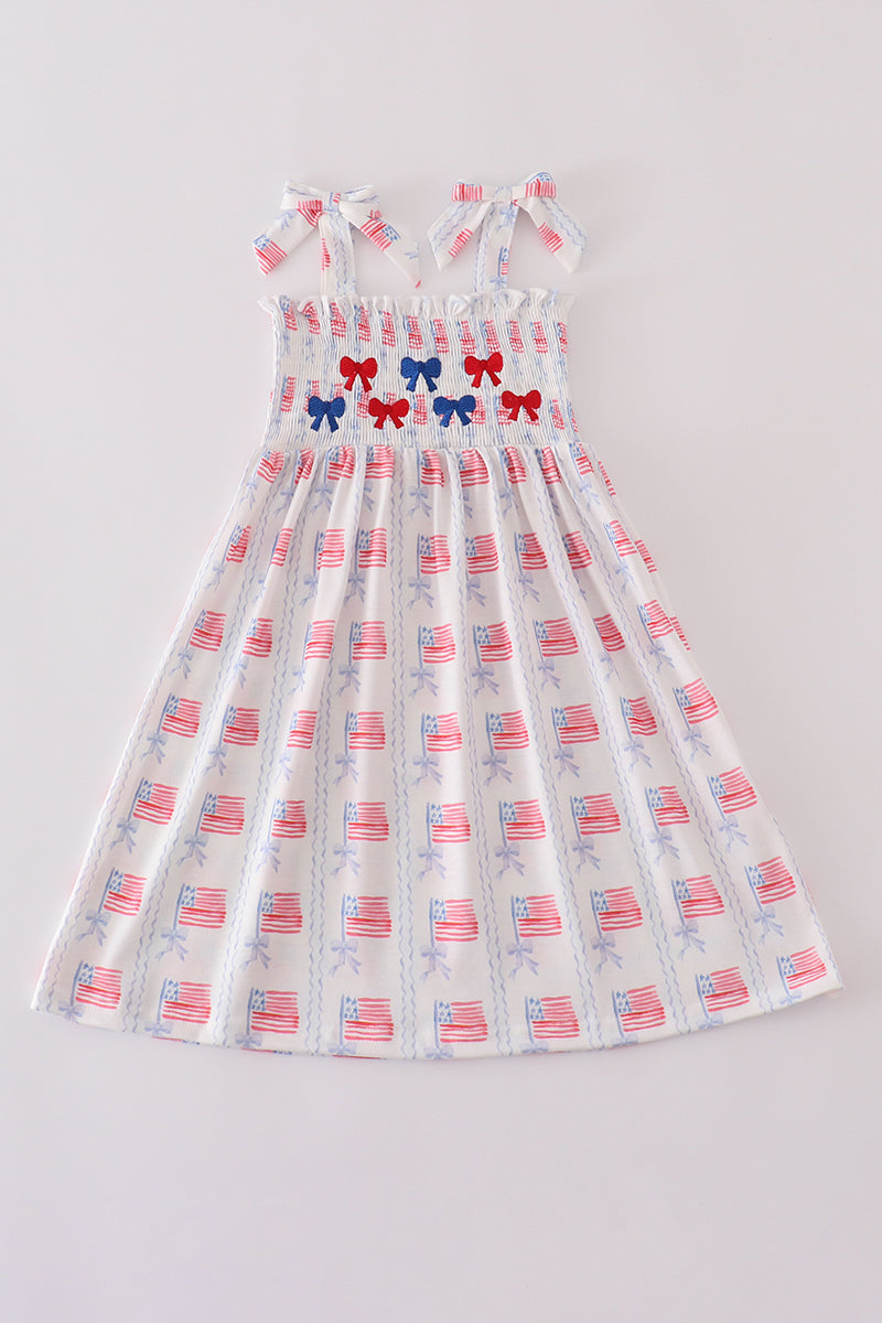 A charming pink smocked dress adorned with delicate bow embroidery, perfect for special occasions.