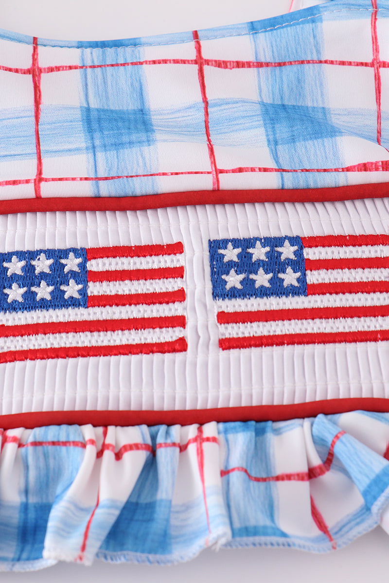 Two-piece swimsuit with flag embroidery, smocked plaid design, and UPF50+ protection.