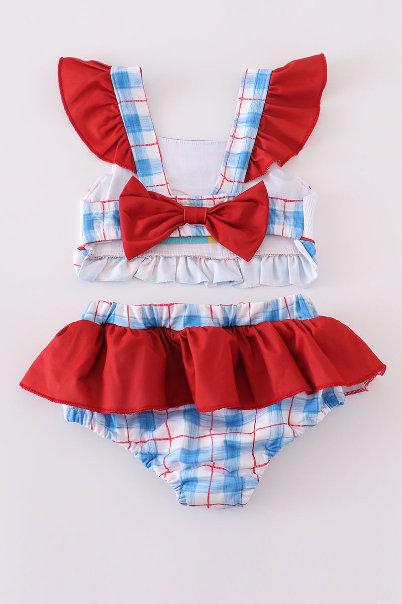 Two-piece swimsuit with flag embroidery, smocked plaid design, and UPF50+ protection.