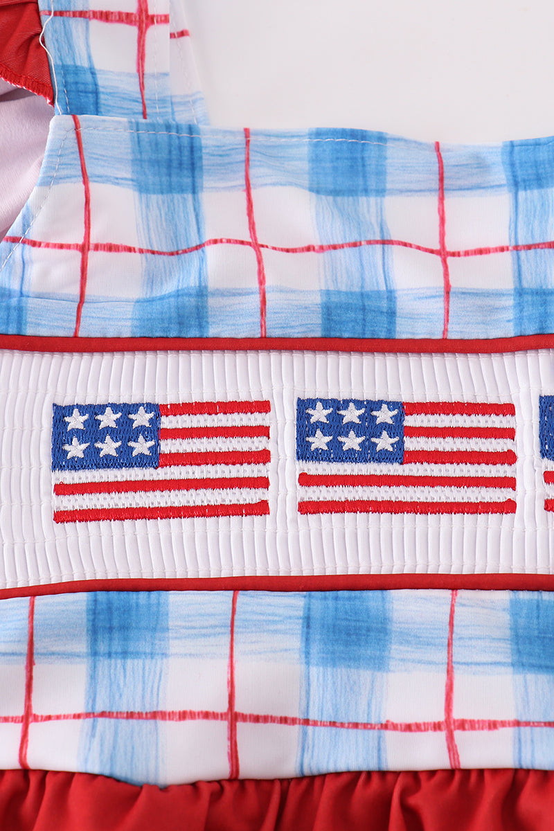 Children’s plaid swimsuit with flag embroidery, smocked details, and UPF50+ protection.