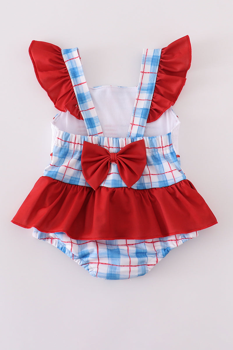 Children’s plaid swimsuit with flag embroidery, smocked details, and UPF50+ protection.