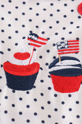 Adorable red ruffle bubble with cake embroidery and playful polka dots.
