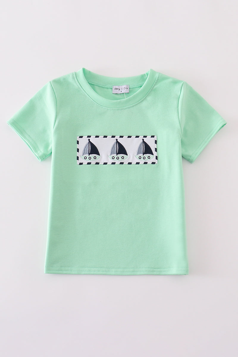 Green seersucker top with playful sailboat embroidery, perfect for summer adventures.