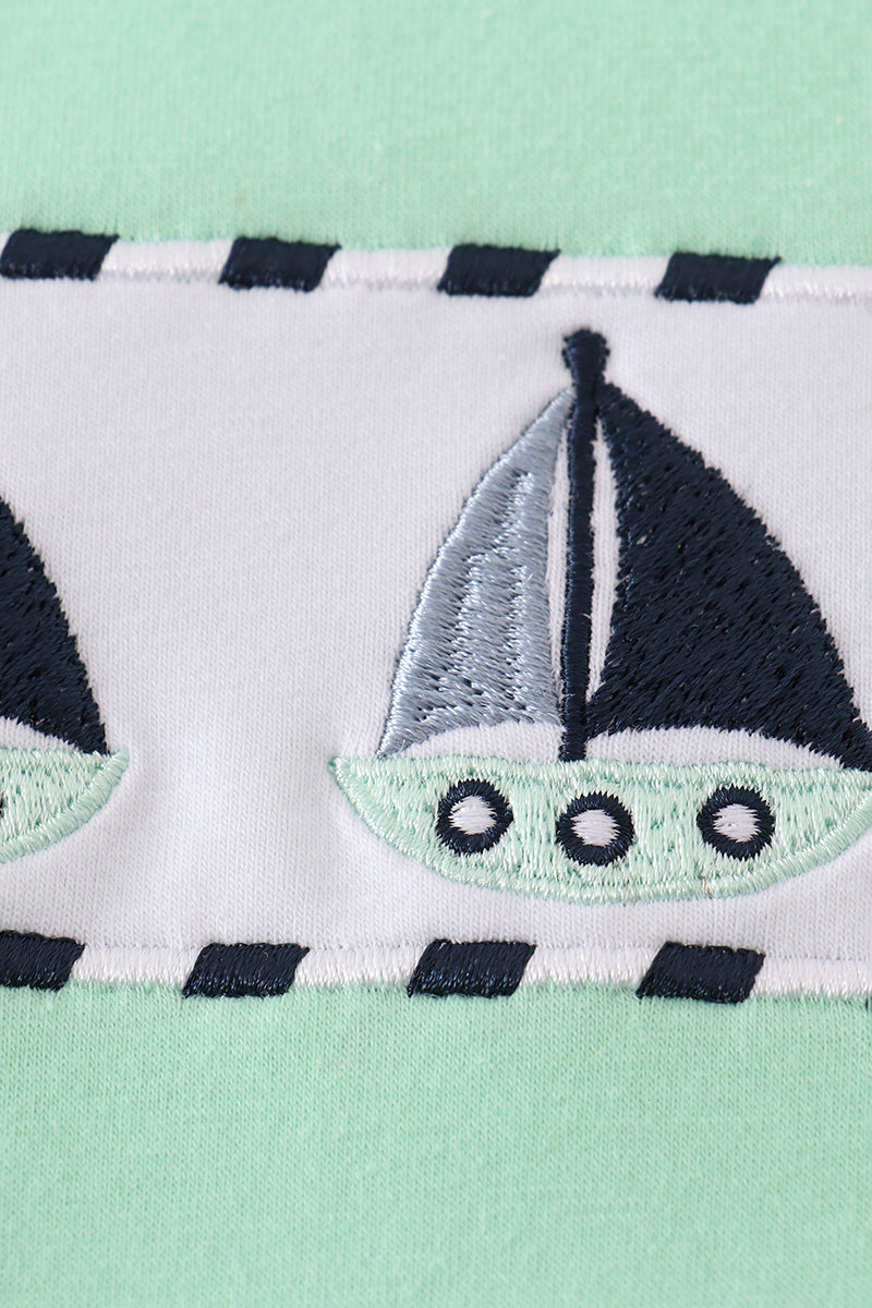 Green seersucker top with playful sailboat embroidery, perfect for summer adventures.