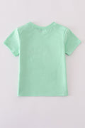 Green seersucker top with playful sailboat embroidery, perfect for summer adventures.