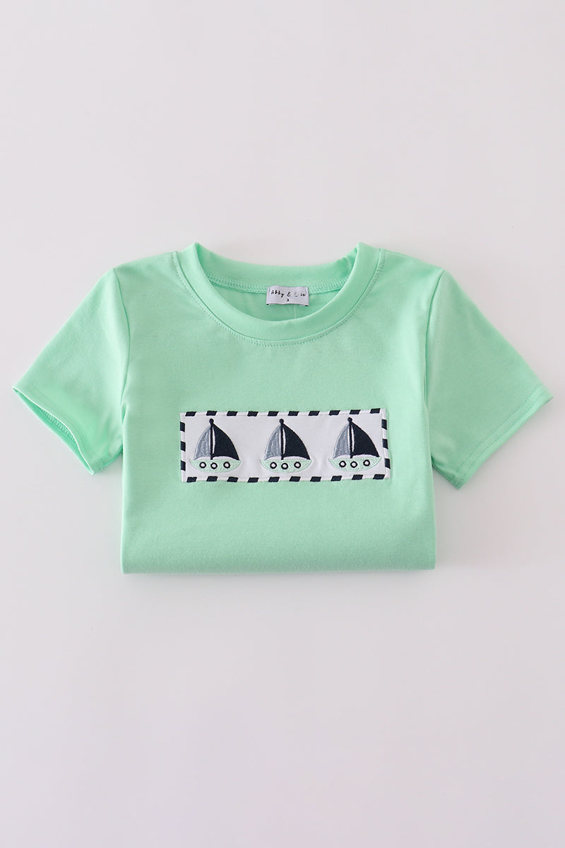 Green seersucker top with playful sailboat embroidery, perfect for summer adventures.