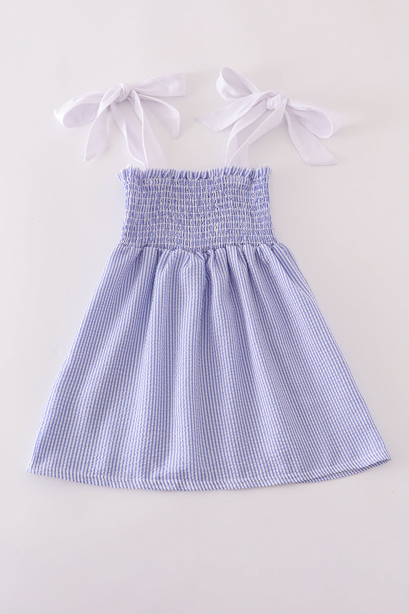 Blue stripe seersucker smocked dress with ruffled sleeves, perfect for family outings.