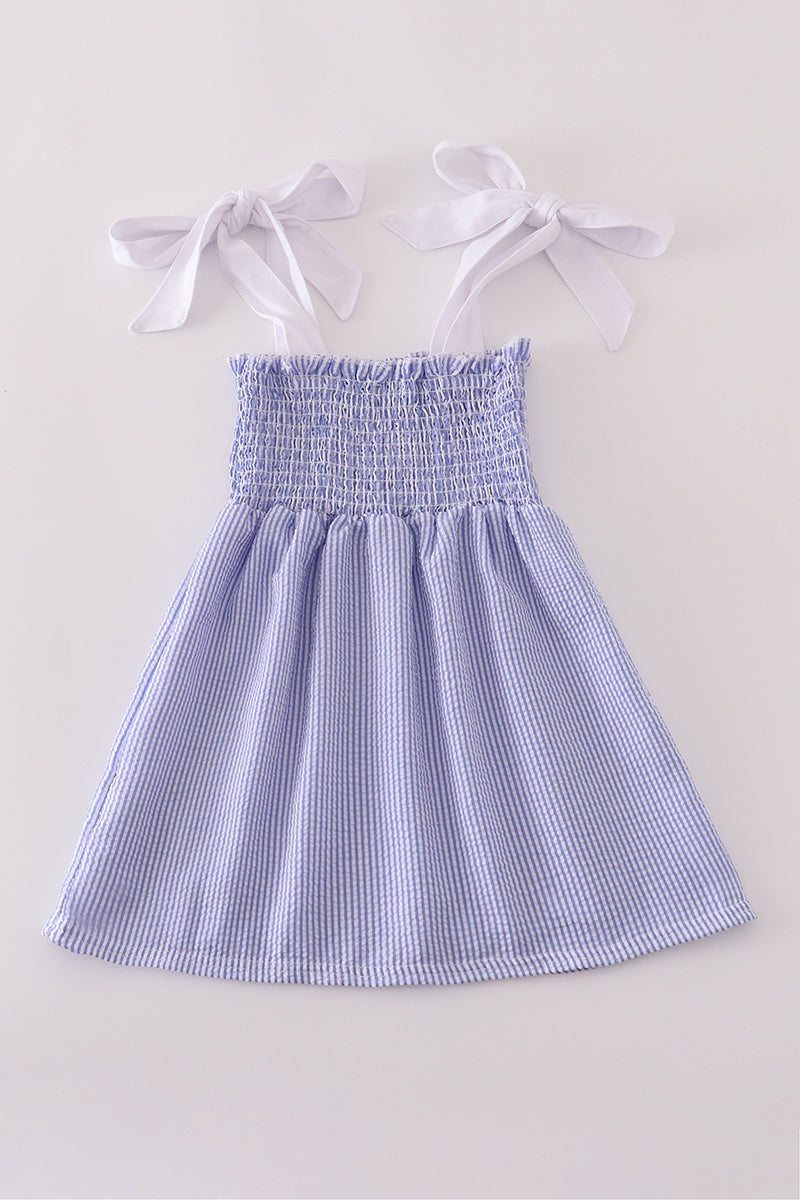 Blue stripe seersucker smocked dress with ruffled sleeves, perfect for family outings.