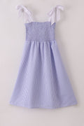 Blue stripe seersucker smocked dress with ruffled sleeves, perfect for family outings.