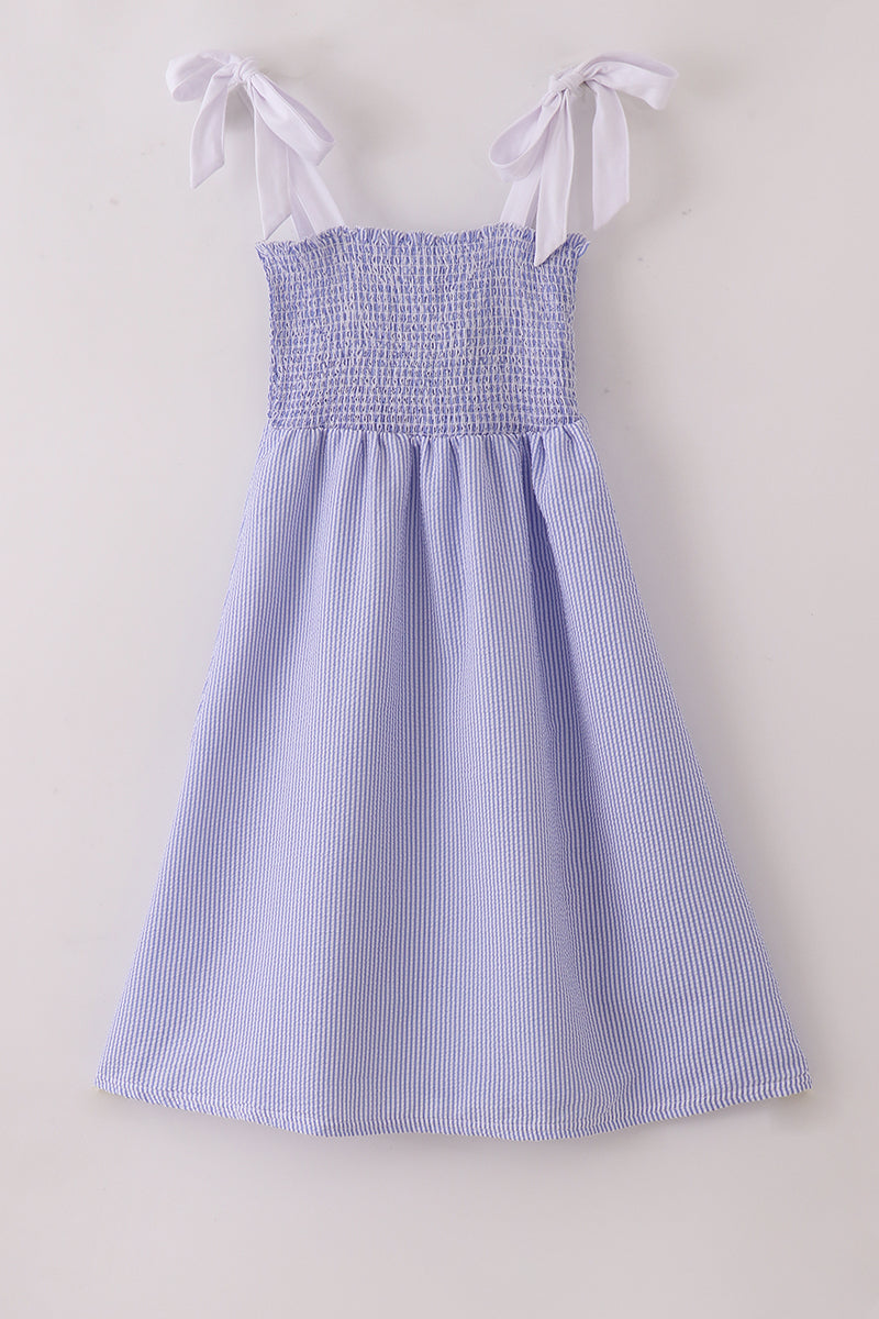 Blue stripe seersucker smocked dress with ruffled sleeves, perfect for family outings.