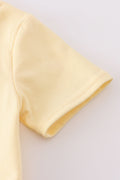 Bright yellow bubble romper with a playful truck applique, perfect for toddlers.