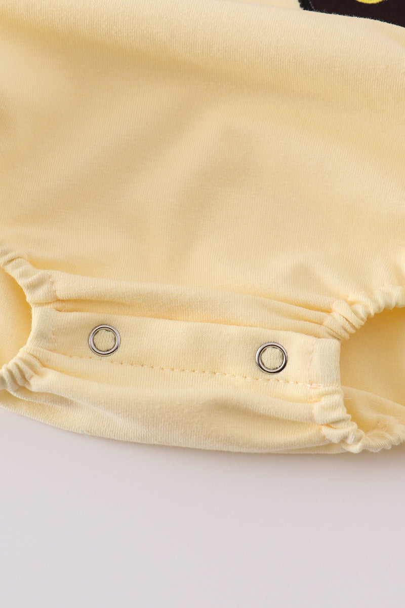 Bright yellow bubble romper with a playful truck applique, perfect for toddlers.
