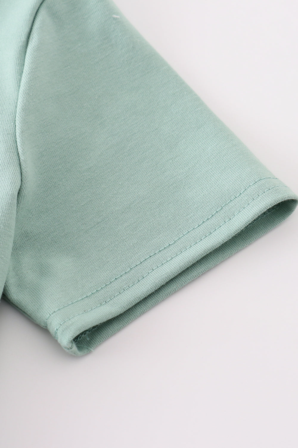 Green top with playful duck applique, perfect for kids' everyday adventures.