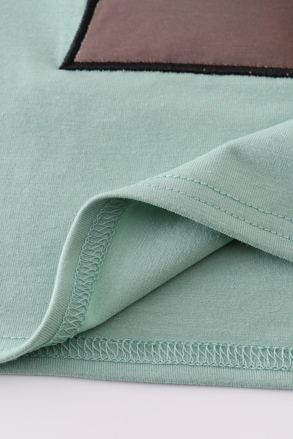Green top with playful duck applique, perfect for kids' everyday adventures.