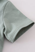 Sage stripe button down shirt with playful green and white pattern.