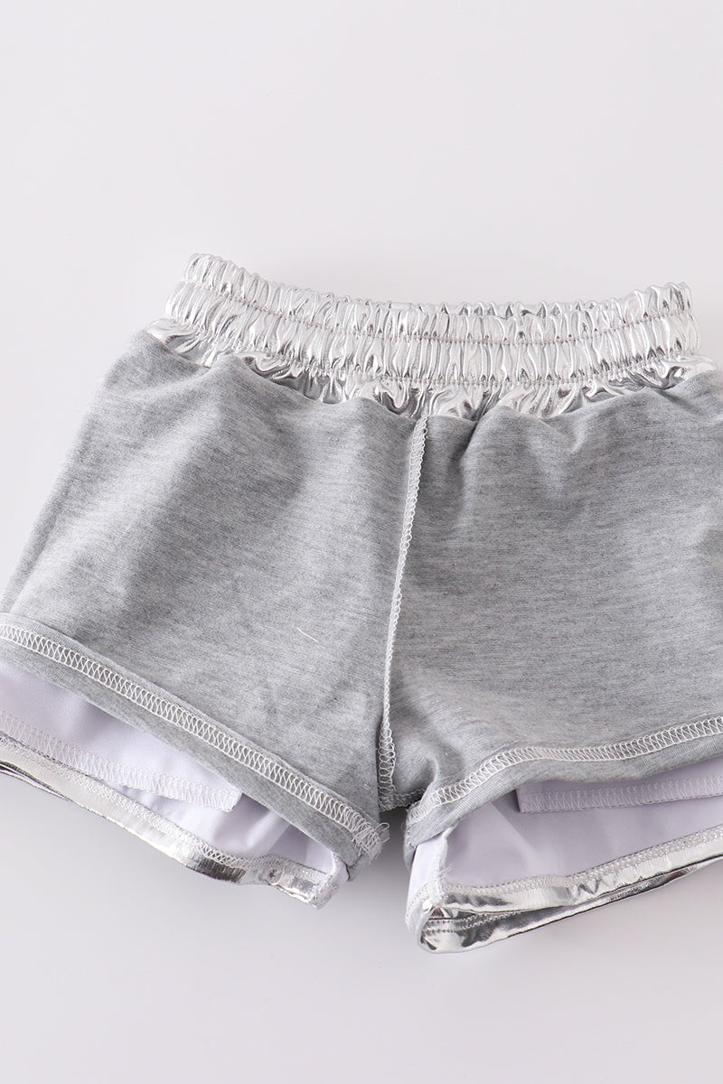 Shiny silver shorts with a fun, futuristic laser pattern, perfect for playtime.