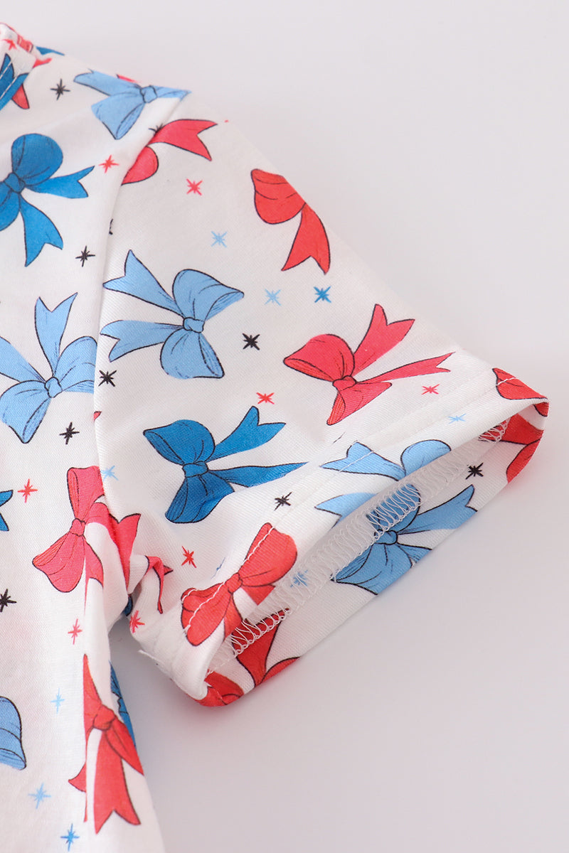 Matching mom and daughter dresses with cute bow appliques on a playful print.