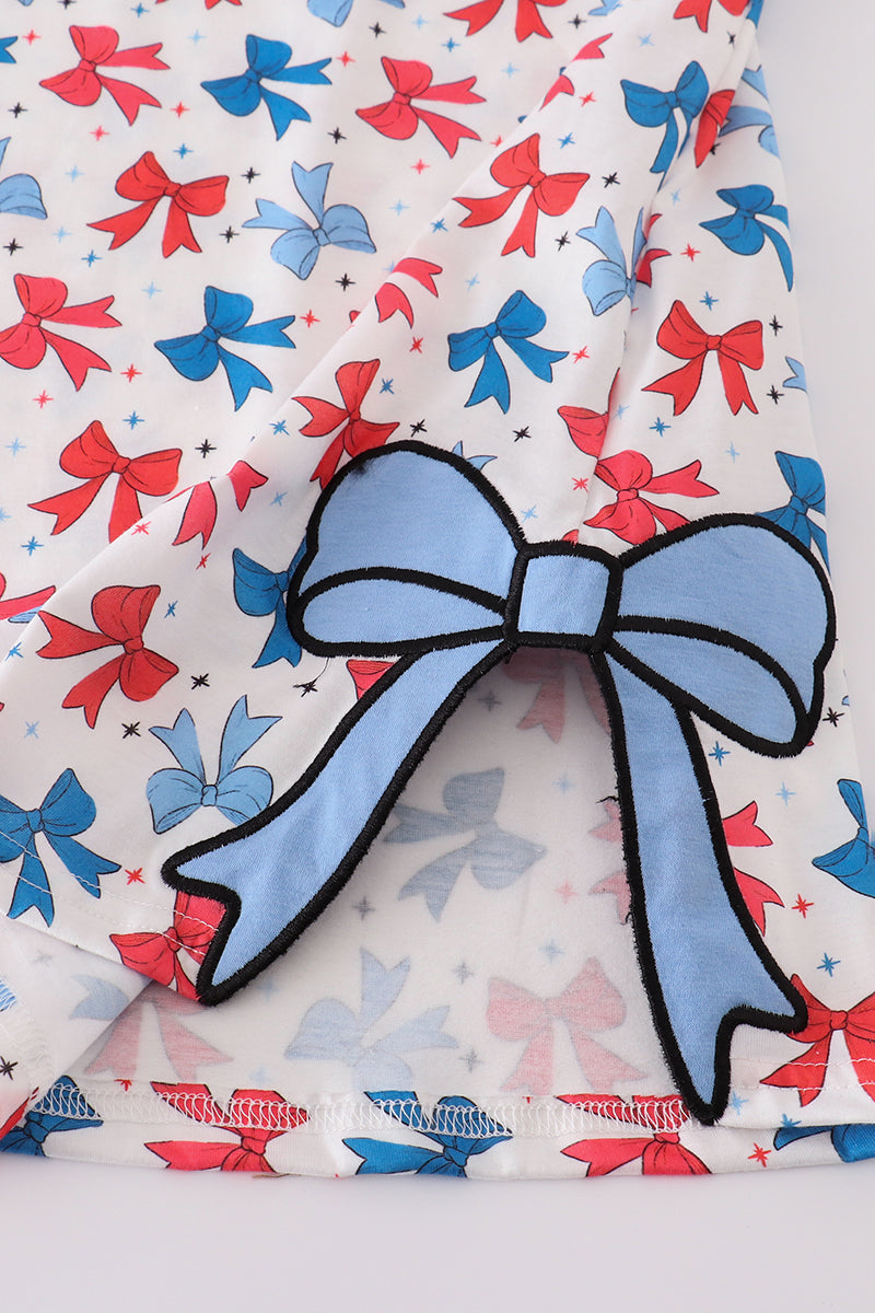 Matching mom and daughter dresses with cute bow appliques on a playful print.