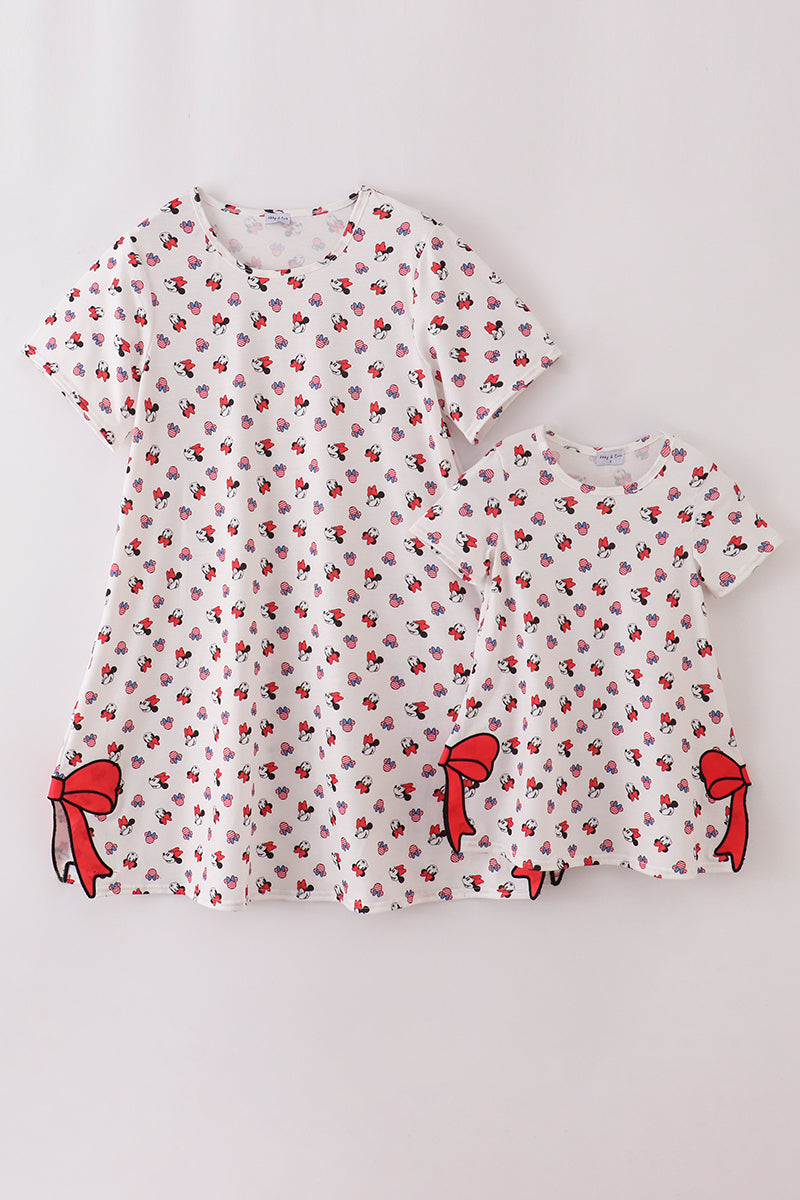 Matching mom and child dresses with playful character print and cute bow details.