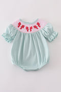 A charming blue bubble romper with pearl smocking and a cute bow accent.
