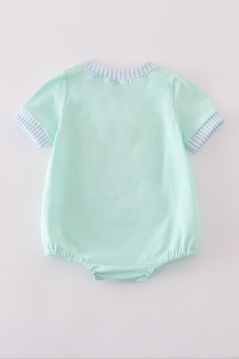 Mint green bubble romper with a whimsical castle applique, perfect for playtime.