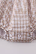 Adorable bubble romper with intricate cross embroidery, perfect for special occasions.