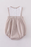 Adorable bubble romper with intricate cross embroidery, perfect for special occasions.